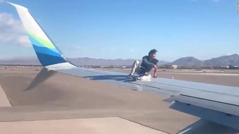 Man was taken into custody after he climbed onto the wing of an airplane preparing to takeoff in Las Vegas
