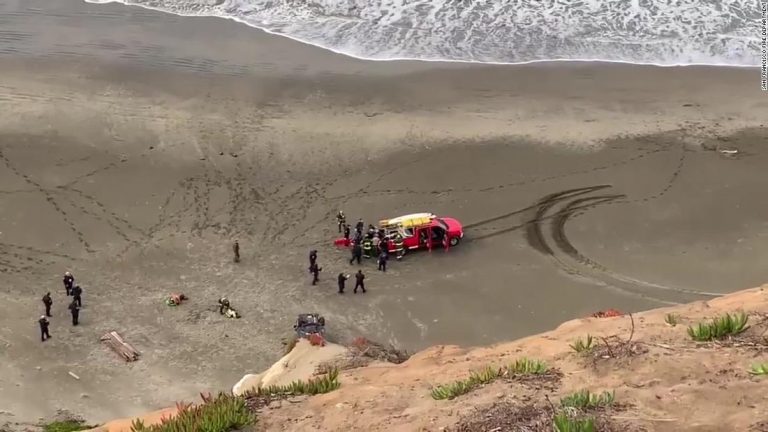Woman rescued after car plunges off cliff onto beach