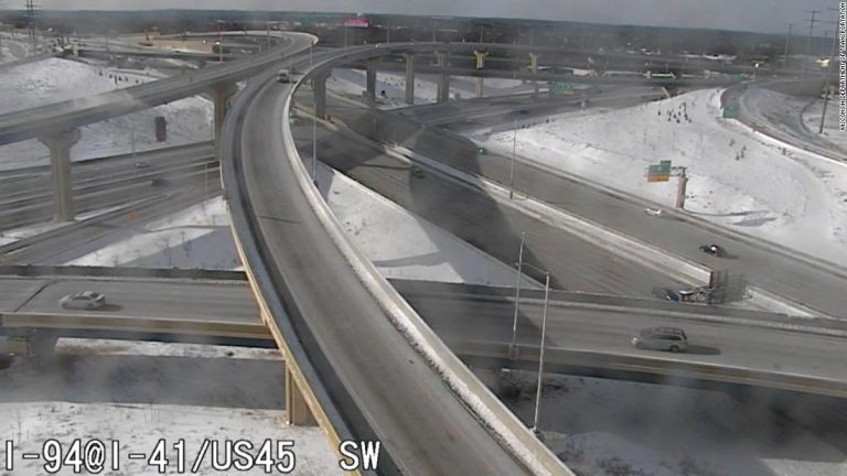 Truck driver survives 70-foot plunge off an icy roadway as freezing weather snarls traffic across Midwest