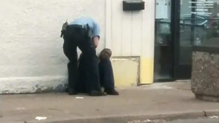 Cell phone video captured by a witness shows two officers standing above Floyd who is handcuffed, sitting on the ground