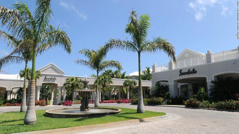 An American woman stricken at a resort in the Bahamas is now hospitalized in Miami, official says